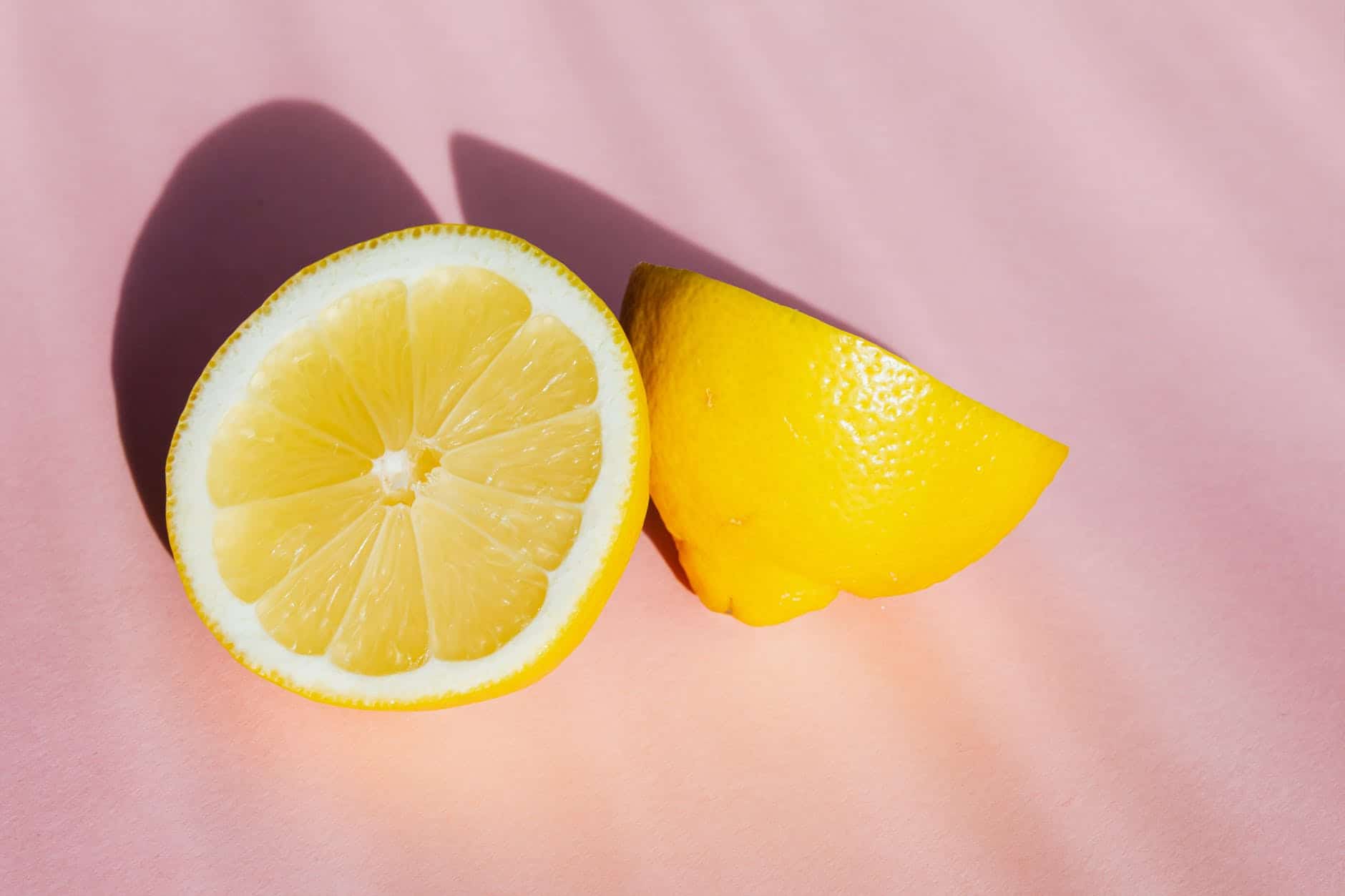 sliced pieces of lemon on pink surface