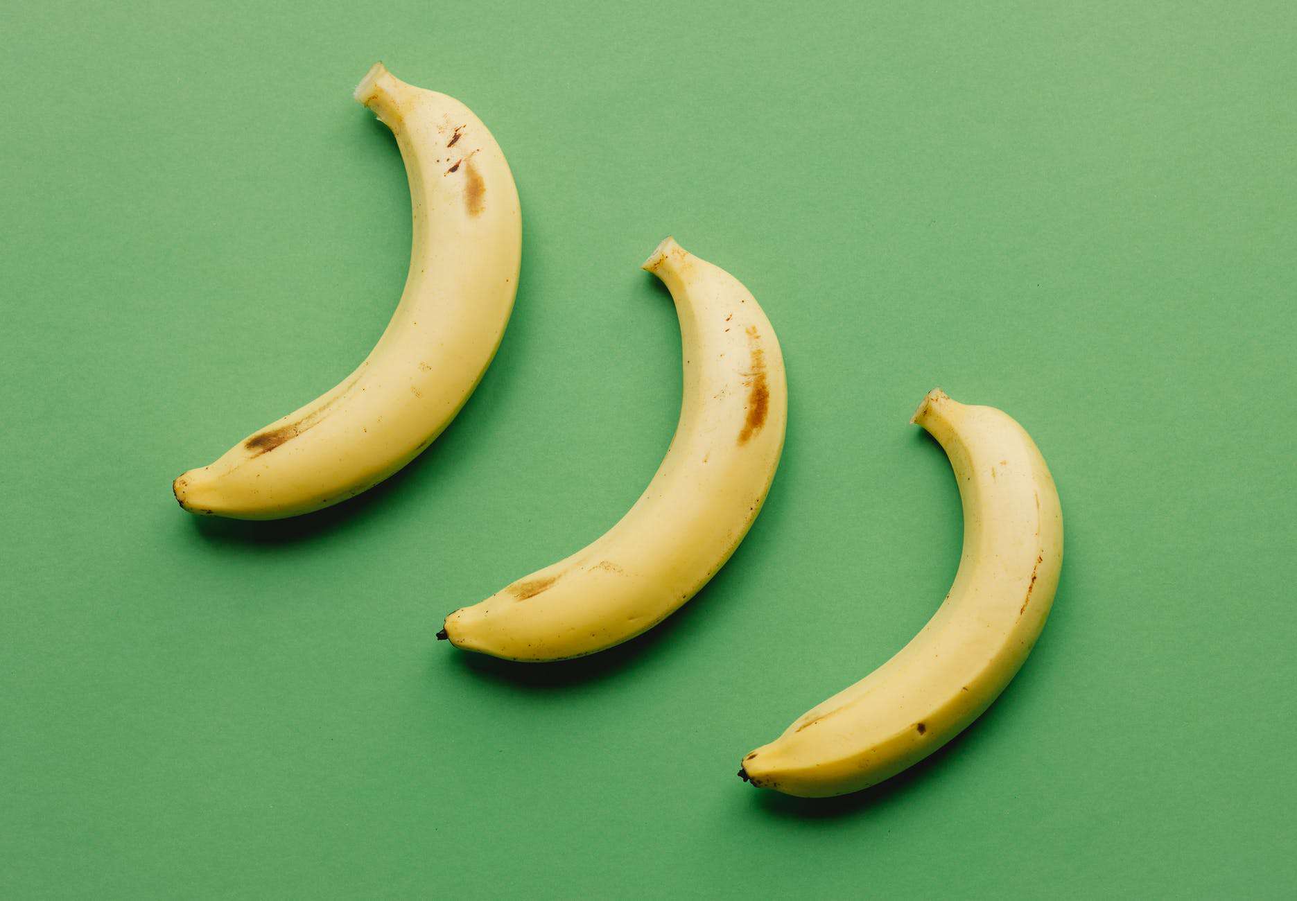 ripe bananas on green surface