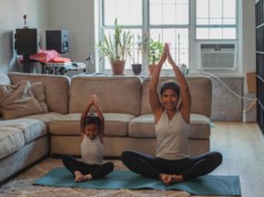 happy mother and daughter stretching together at home