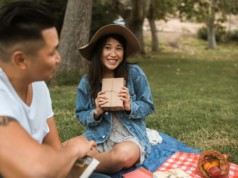 asian couple on a picnic ground with books