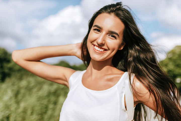 Smiling woman outdoors on sunny day